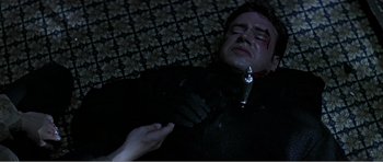 Movie still from “Scream 3” (2000), directed by Wes Craven – A man is laying down on the ground with a knife in his hand; Close Up shot, Overhead angle