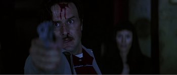 Movie still from “Scream 3” (2000), directed by Wes Craven – A man with blood on his face looking at the camera; Close Up shot, Low angle