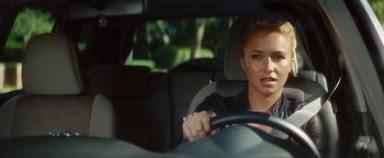 Movie still from “Scream 4” (2011), directed by Wes Craven – A woman driving a car in a car with trees in the background; Close Up shot, Over the shoulder angle
