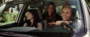 Movie still from “Scream 4” (2011), directed by Wes Craven – Three young women sitting in the back seat of a car; Medium shot, Over the shoulder angle