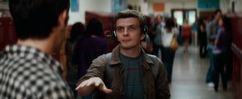Movie still from “Scream 4” (2011), directed by Wes Craven – A young man wearing a headset is holding his hand out to the camera; Medium shot, Over the shoulder angle