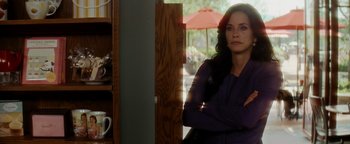 Movie still from “Scream 4” (2011), directed by Wes Craven – A woman standing in a room with her arms crossed; Medium shot, Over the shoulder angle