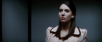 Movie still from “Scream 4” (2011), directed by Wes Craven – A woman in a pink jacket is holding her collar; Close Up shot, Over the shoulder angle