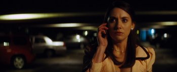 Movie still from “Scream 4” (2011), directed by Wes Craven – A woman talking on a cell phone while standing in a parking lot at night; Close Up shot, Low angle