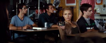Movie still from “Scream 4” (2011), directed by Wes Craven – A woman sitting at a table holding up a camera; Medium shot, Over the shoulder angle