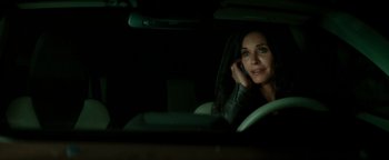 Movie still from “Scream 4” (2011), directed by Wes Craven – A woman sitting in the driver's seat of a car while talking on a cell phone; Close Up shot, Over the shoulder angle