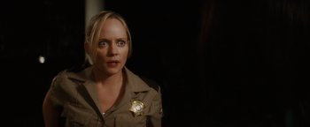 Movie still from “Scream 4” (2011), directed by Wes Craven – A woman in a sheriff's uniform looking at the camera; Close Up shot, Over the shoulder angle