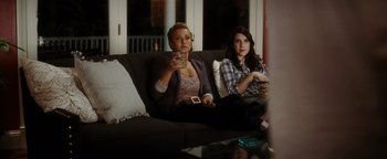 Movie still from “Scream 4” (2011), directed by Wes Craven – Two women sitting on a couch watching television; Medium shot, Over the shoulder angle