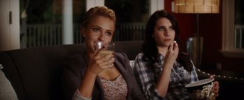 Movie still from “Scream 4” (2011), directed by Wes Craven – Two young women sitting on a couch holding drinks; Medium shot, Over the shoulder angle