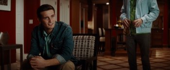 Movie still from “Scream 4” (2011), directed by Wes Craven – A man sitting on a chair in a living room; Medium shot, Over the shoulder angle