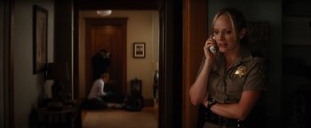 Movie still from “Scream 4” (2011), directed by Wes Craven – A woman talking on a phone in a living room; Medium shot, Over the shoulder angle