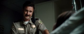 Movie still from “Scream 4” (2011), directed by Wes Craven – A man in a sheriff's uniform looking into a mirror; Close Up shot, Over the shoulder angle