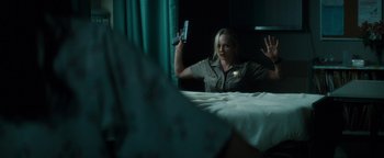 Movie still from “Scream 4” (2011), directed by Wes Craven – A woman holding a gun in front of a mirror; Medium shot, Over the shoulder angle
