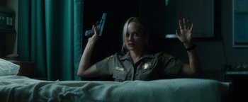 Movie still from “Scream 4” (2011), directed by Wes Craven – A woman holding up a gun while sitting on a bed; Medium shot, Low angle