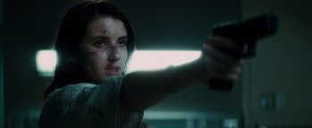 Movie still from “Scream 4” (2011), directed by Wes Craven – A woman holding a gun while standing in a dark room; Close Up shot, Low angle