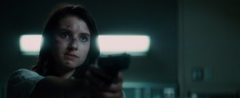 Movie still from “Scream 4” (2011), directed by Wes Craven – A woman is holding a gun in a room; Close Up shot, Low angle
