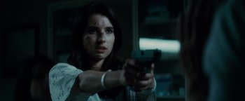 Movie still from “Scream 4” (2011), directed by Wes Craven – A woman holding a gun in a dark room; Close Up shot, Low angle