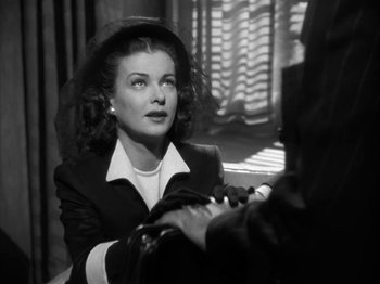 Movie still from “Secret Beyond the Door...” (1947), directed by Fritz Lang – An old black and white photo of a woman in a suit; Close Up shot, Over the shoulder angle