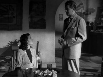 Movie still from “Secret Beyond the Door...” (1947), directed by Fritz Lang – A man and a woman are standing at a table; Medium shot, Low angle