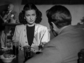 Movie still from “Secret Beyond the Door...” (1947), directed by Fritz Lang – A woman sitting at a table with a man; Medium shot, Over the shoulder angle