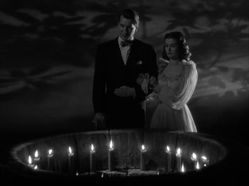Movie still from “Secret Beyond the Door...” (1947), directed by Fritz Lang – A man and a woman standing in front of lit candles; Medium shot, High angle