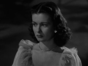 Movie still from “Secret Beyond the Door...” (1947), directed by Fritz Lang – A black - and - white photo of a woman in a white dress; Close Up shot, High angle