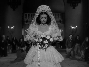 Movie still from “Secret Beyond the Door...” (1947), directed by Fritz Lang – A woman in a wedding dress holding a bouquet of flowers; Medium shot, Low angle