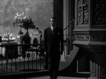 Movie still from “Secret Beyond the Door...” (1947), directed by Fritz Lang – A man in a suit and tie walking down a staircase; Wide shot, Low angle