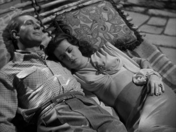 Movie still from “Secret Beyond the Door...” (1947), directed by Fritz Lang – An older man and a younger woman laying on a porch swing; Medium shot, High angle