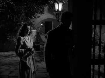 Movie still from “Secret Beyond the Door...” (1947), directed by Fritz Lang – A man and a woman standing next to each other in the dark; Medium shot, Low angle