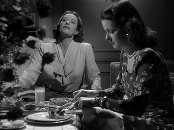Movie still from “Secret Beyond the Door...” (1947), directed by Fritz Lang – Two women sitting at a dinner table with a plate in front of them; Medium shot, Low angle