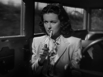 Movie still from “Secret Beyond the Door...” (1947), directed by Fritz Lang – A black and white photo of a woman smoking a cigarette; Close Up shot, Low angle