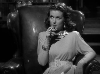 Movie still from “Secret Beyond the Door...” (1947), directed by Fritz Lang – A black and white photo of a woman smoking a cigarette; Close Up shot, Low angle