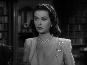 Movie still from “Secret Beyond the Door...” (1947), directed by Fritz Lang – A black - and - white photo of a woman in a dress; Close Up shot, Over the shoulder angle