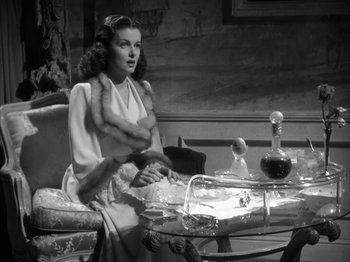 Movie still from “Secret Beyond the Door...” (1947), directed by Fritz Lang – A woman sitting at a table in a living room; Medium shot, High angle