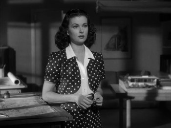 Movie still from “Secret Beyond the Door...” (1947), directed by Fritz Lang – A woman in a polka dot dress standing in front of a table; Medium shot, Over the shoulder angle