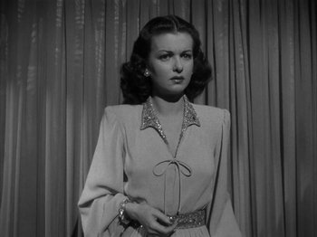 Movie still from “Secret Beyond the Door...” (1947), directed by Fritz Lang – An old photo of a woman standing in front of a curtain; Medium shot, Low angle