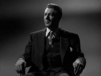 Movie still from “Secret Beyond the Door...” (1947), directed by Fritz Lang – A black and white photo of a man in a suit and tie; Medium shot, Low angle