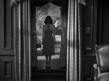 Movie still from “Secret Beyond the Door...” (1947), directed by Fritz Lang – A black and white photo of a woman standing in a doorway; Wide shot, Low angle