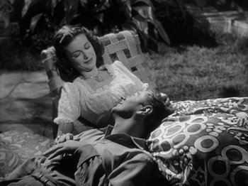 Movie still from “Secret Beyond the Door...” (1947), directed by Fritz Lang – A man and a woman laying on a lawn chair; Medium shot, High angle