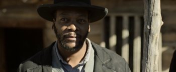 Movie still from “Godless” (2017), directed by Scott Frank – A man wearing a hat and a jacket; Close Up shot, Over the shoulder angle