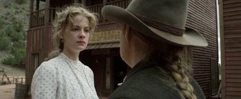Movie still from “Godless” (2017), directed by Scott Frank – A woman standing next to a man wearing a cowboy hat; Close Up shot, Over the shoulder angle