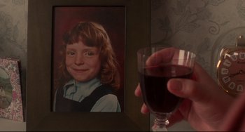 Movie still from “Secrets & Lies” (1996), directed by Mike Leigh – A person holding a wine glass in front of a picture of a girl; Extreme Close Up shot, High angle