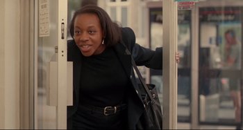Movie still from “Secrets & Lies” (1996), directed by Mike Leigh – A woman in a black dress and a black purse; Medium shot, Low angle