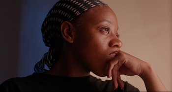 Movie still from “Secrets & Lies” (1996), directed by Mike Leigh – A person wearing a headscarf; Close Up shot, Low angle