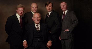 Movie still from “Secrets & Lies” (1996), directed by Mike Leigh – A group of men in business suits posing for a picture; Medium shot, Low angle