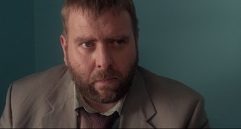 Movie still from “Secrets & Lies” (1996), directed by Mike Leigh – A person wearing a suit and tie; Close Up shot, Over the shoulder angle