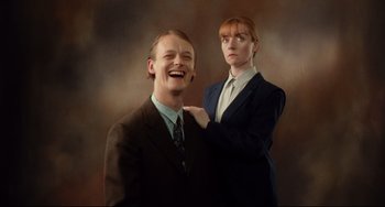 Movie still from “Secrets & Lies” (1996), directed by Mike Leigh – A man and a woman posing for a picture; Medium shot, Low angle