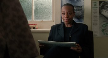 Movie still from “Secrets & Lies” (1996), directed by Mike Leigh – A woman sitting in front of a window holding a newspaper; Close Up shot, Over the shoulder angle