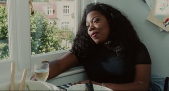 Movie still from “Secrets & Lies” (1996), directed by Mike Leigh – A woman sitting in front of a window with a plate of food in front of her; Medium shot, Low angle